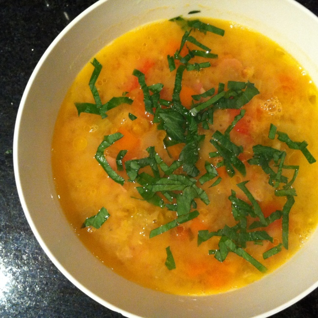 White bowl with red lentil soup and parsley